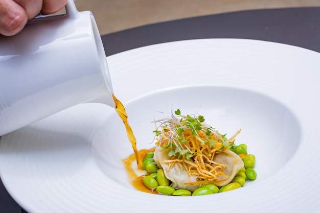 Szef kuchni nakładający sos na talerz